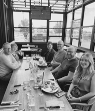 A group of people smiling for a restaurant table photo