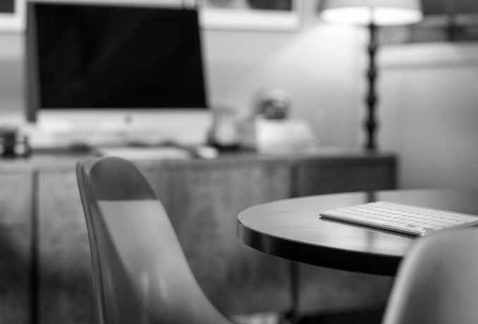 Table and chairs in an office with a computer monitor in the background